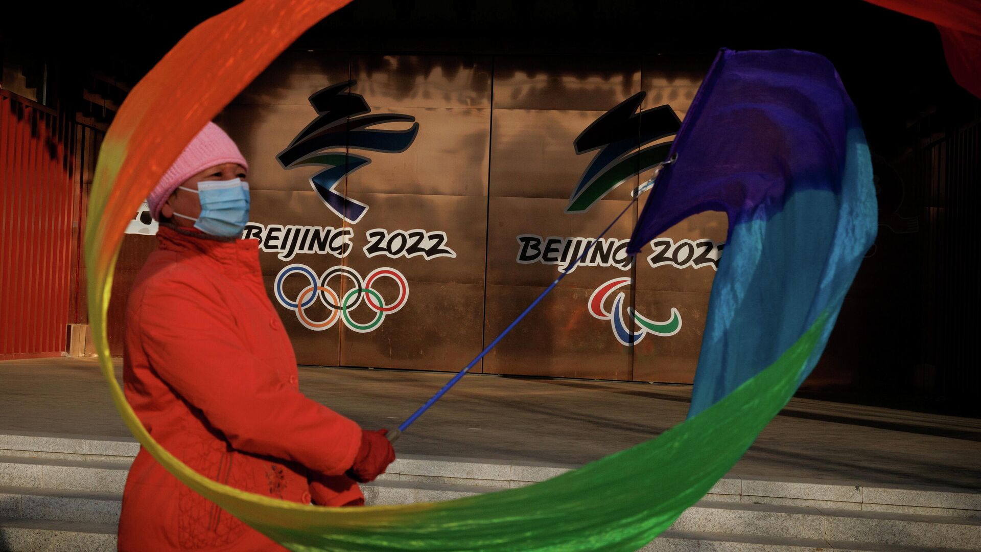 Una mujer con una cinta cerca de los logotipos de los Juegos Olímpicos y Paralímpicos de Pekín 2022 en un parque, China, el 8 de diciembre de 2021 - Sputnik Mundo, 1920, 09.12.2021