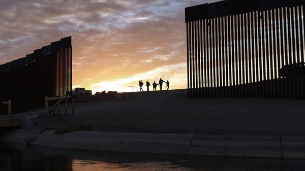 Una familia camina cerca de la frontera entre Estados Unidos y México - Sputnik Mundo