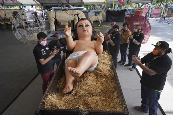La familia Gómez Resendiz da una ronda de aplausos para celebrar la colocación de una gigantesca estatua del Niño Jesús en la plaza de Iztapalapa en la Ciudad de México durante los preparativos para la Navidad. - Sputnik Mundo