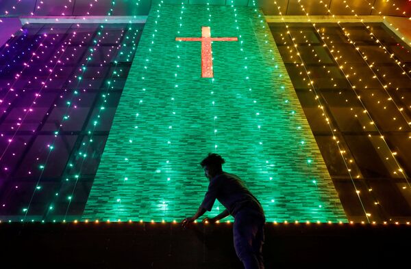 La víspera de la Navidad se llama Nochebuena o Vigilia.En la foto: iluminación navideña en una iglesia de Ahmedabad, en la India. - Sputnik Mundo