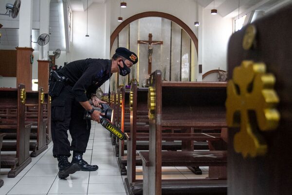La principal misa de Navidad se celebra en El Vaticano.En la foto: un agente de Policía inspecciona una iglesia en Sleman, Indonesia, antes de una misa navideña. - Sputnik Mundo