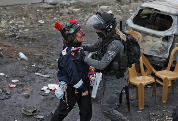 Un manifestante disfrazado de payaso junto a una agente de Policía durante una protesta en Jerusalén Este. - Sputnik Mundo