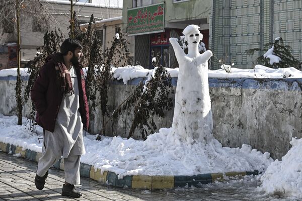Un hombre pasa al lado de una figura de nieve en Kabul, Afganistán, el 5 de enero de 2022. - Sputnik Mundo