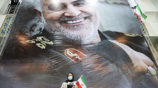 Una mujer iraní sostiene una foto del general iraní Qasem Soleimani durante una ceremonia para conmemorar el segundo aniversario de su asesinato, en Teherán, Irán, el 3 de enero de 2022 - Sputnik Mundo
