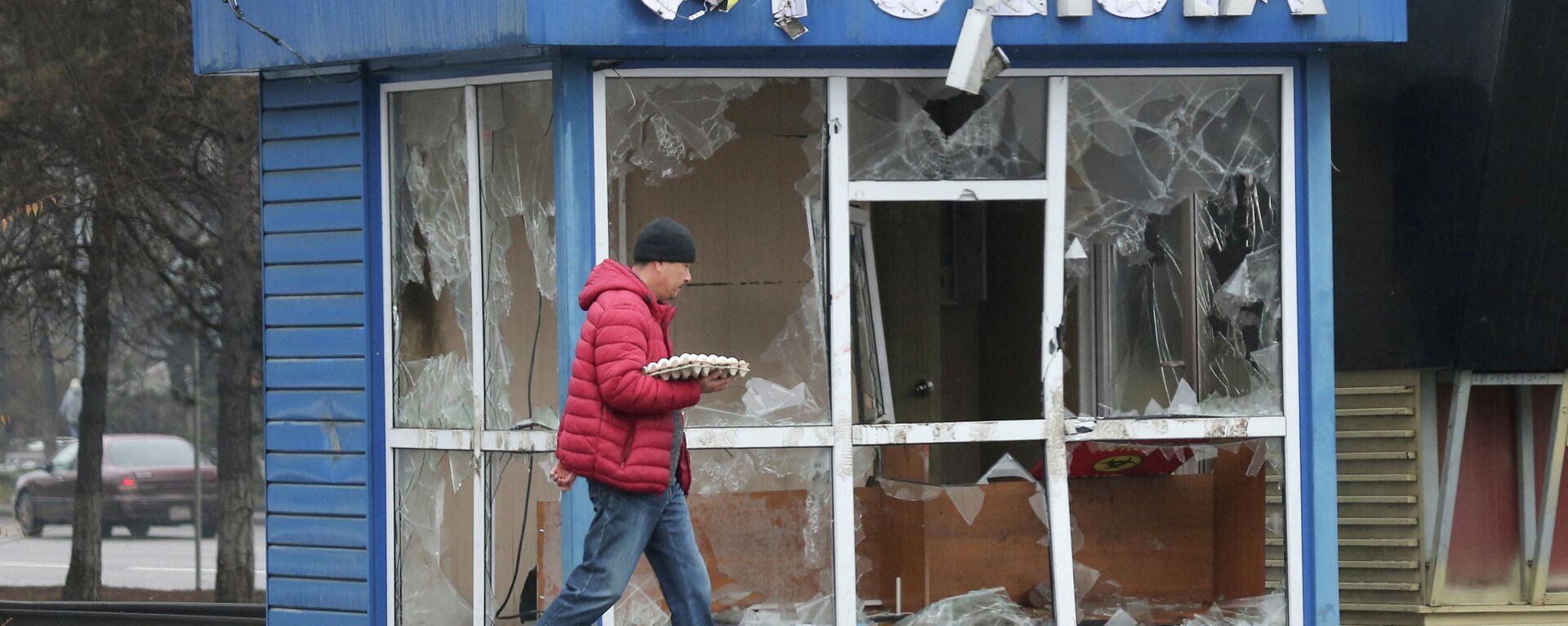 Un hombre pasa frente a una estación de Policía, destrozada durante las protestas masivas provocadas por el aumento del precio del combustible, en Almaty, Kazajistán, el 8 de enero de 2022 - Sputnik Mundo, 1920, 08.01.2022