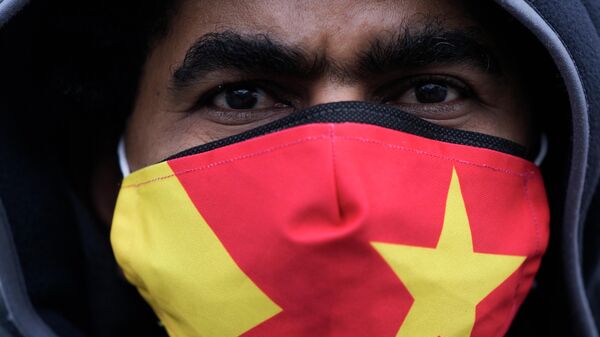 Un manifestante lleva una máscara con los colores de la bandera regional de Tigray mientras asiste a una protesta en Berlín, Alemania - Sputnik Mundo