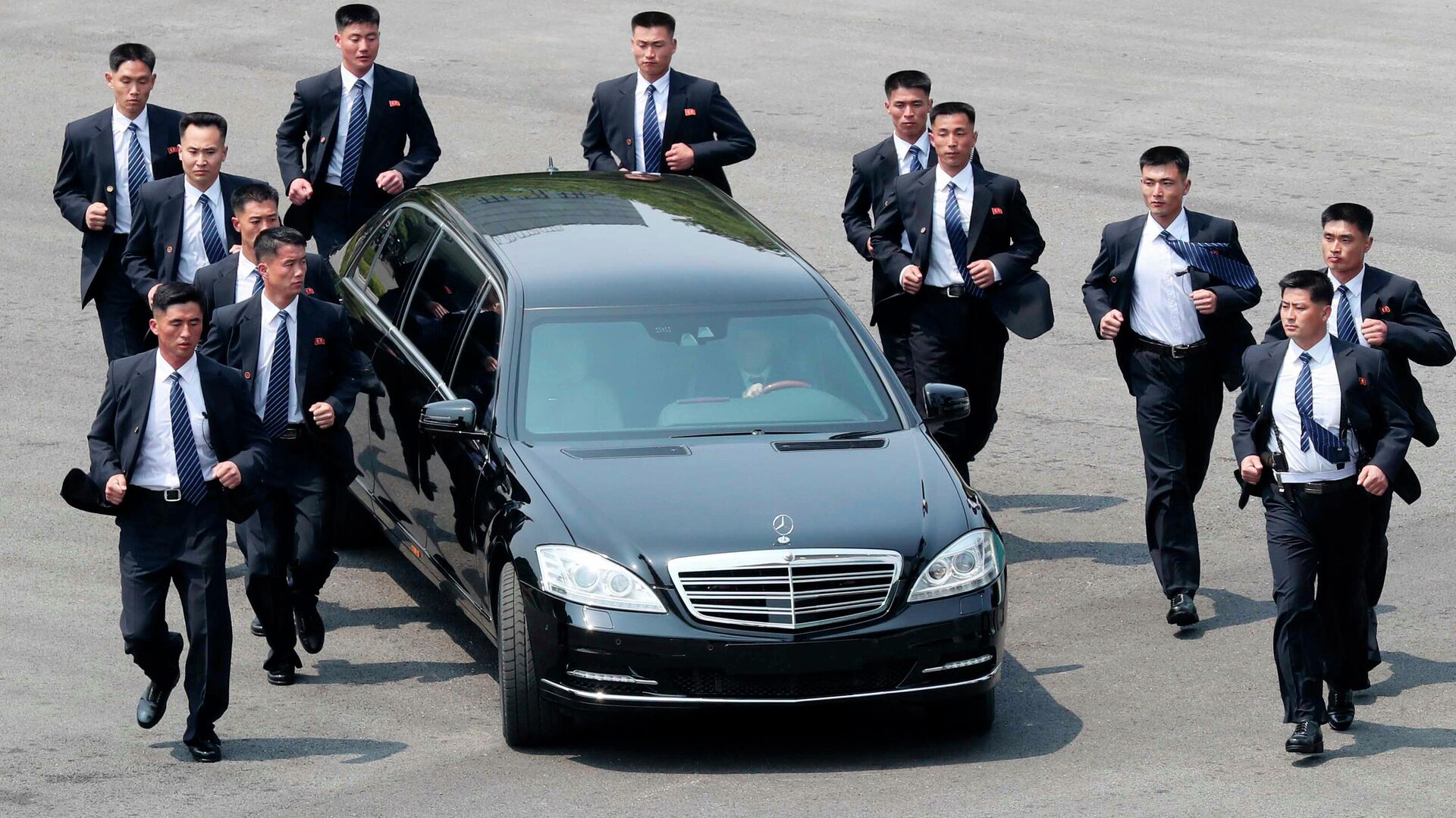 Unos agentes de seguridad  norcoreanos acompañan el automóvil que transporta al líder norcoreano Kim Jong-un tras un encuentro con el presidente surcoreano Moon Jae-in. - Sputnik Mundo, 1920, 15.01.2022