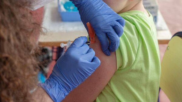 Un niño recibe la vacuna contra el Covid-19, en el CEIP Manel García Grau, a 13 de enero de 2022, - Sputnik Mundo