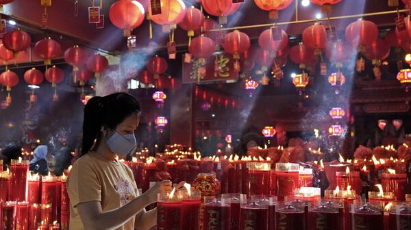 Зажжение свечи в храме во время празднования Нового года по лунному календарю в Индонезии  - Sputnik Mundo