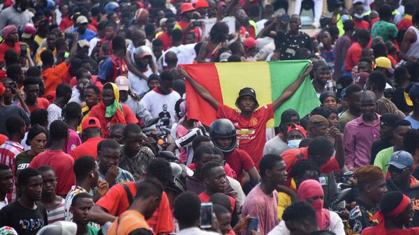 Un partidario sostiene una bandera nacional guineana mientras los activistas exiliados llegan a Conakry (archivo) - Sputnik Mundo