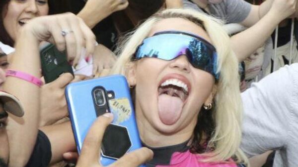 La cantante estadounidense Miley Cyrus saludando fanáticos en Argentina en marzo de 2022 - Sputnik Mundo