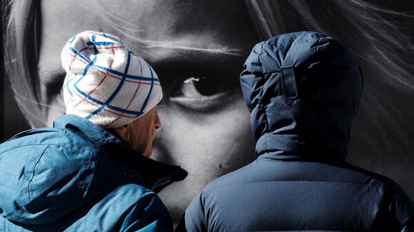 Люди возле одной из фотографий на выставке Пусть всегда будет мама, пусть всегда буду Я! Дети Донбасса на Большой Морской улице в Санкт-Петербурге - Sputnik Mundo