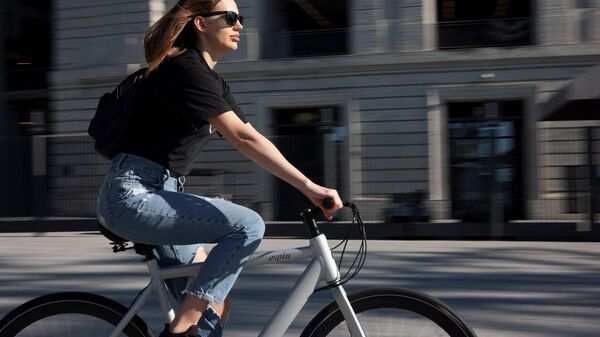 Una mujer en bicicleta eléctrica (imagen referencial) - Sputnik Mundo