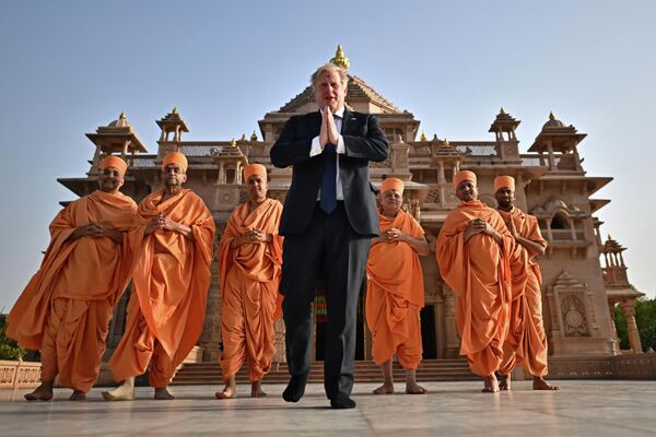 El primer ministro británico, Boris Johnson, posa con unos monjes hindúes conocidos como sadhu frente al templo Akshardham en Gandhinagar, en el oeste de India, el 21 de abril de 2022. - Sputnik Mundo