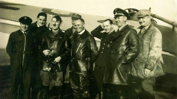 Foto tomada de Hans Baur durante la detención 'Después del vuelo durante la campaña electoral. 2 de septiembre de 1932'. Hans Baur en el centro con un traje de vuelo. - Sputnik Mundo