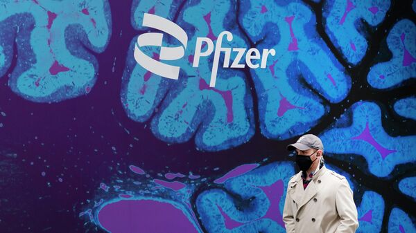 Un hombre pasa por la sede de Pfizer - Sputnik Mundo
