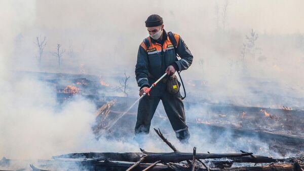 Un empleado del Ministerio de Emergencias de Rusia apagando el fuego (imagen ilustrativa) - Sputnik Mundo