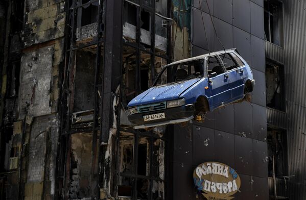 Un rescatista del Ministerio de Situaciones de Emergencia de Rusia evacúa un coche dañado en una de las calles de Mariúpol, en la República Popular de Donetsk. - Sputnik Mundo
