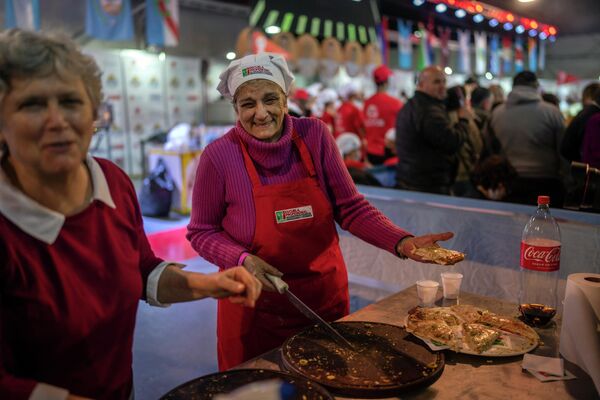 Los voluntarios reparten a los espectadores las pizzas preparadas por los participantes del campeonato. - Sputnik Mundo