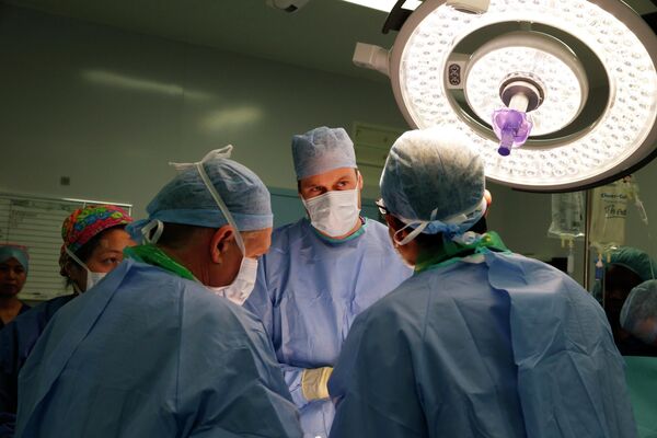El príncipe Guillermo (centro) asiste a una cirugía durante una visita al Hospital Royal Marsden en Londres, el Reino Unido, 2013. - Sputnik Mundo
