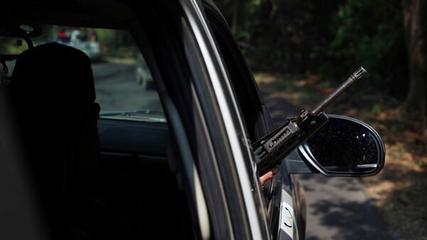 Un hombre con un arma dentro de un automóvil en México - Sputnik Mundo