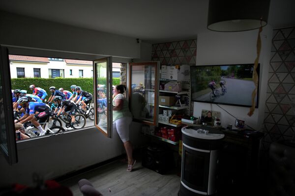 Una residente local saluda a los competidores del Tour de Francia en un pueblo cerca del circuito Dunkerque-Calais, Francia. - Sputnik Mundo