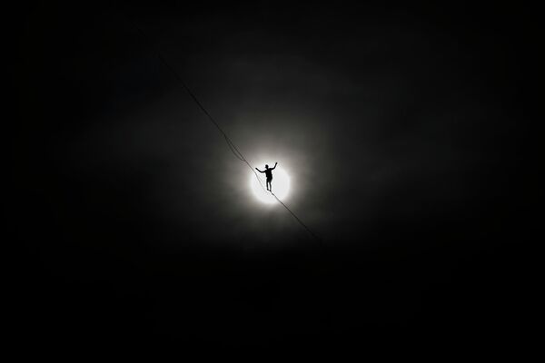 El equilibrista francés Nathan Paulin camina sobre una cuerda floja de 950 metros de longitud, 50 metros sobre el lago de Ginebra, entre las orillas derecha e izquierda de la ciudad de Ginebra durante un evento por el Día Nacional de Suiza. 1 de agosto de 2022. - Sputnik Mundo