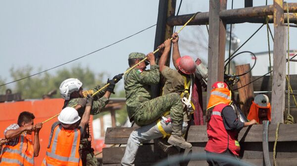 Un grupo de soldados y rescatistas ayuda en las maniobras para rescatar a 10 mineros atrapados en una mina en el norte de México - Sputnik Mundo