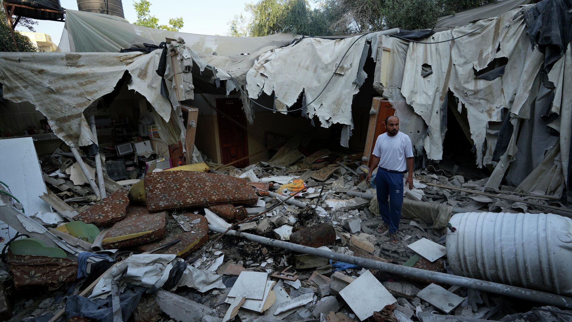 Rami Arada, inspecciona los escombros de la casa de su familia después de que fuera destruida por un ataque aéreo israelí, en el sur de la Franja de Gaza  - Sputnik Mundo, 1920, 18.03.2023