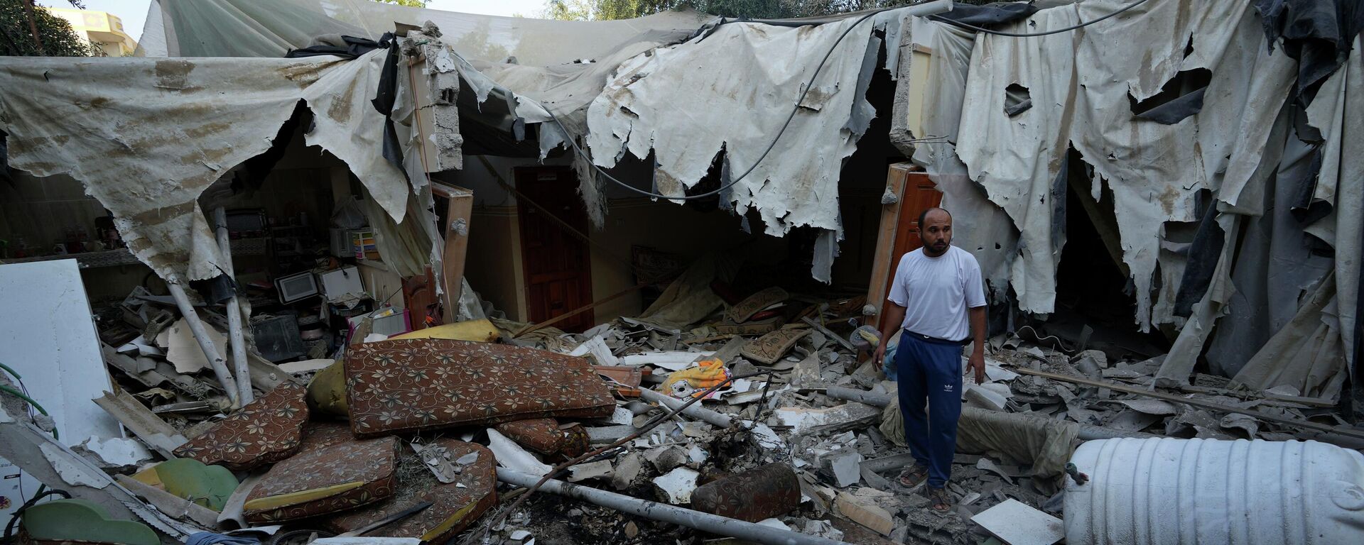 Rami Arada, inspecciona los escombros de la casa de su familia después de que fuera destruida por un ataque aéreo israelí, en el sur de la Franja de Gaza - Sputnik Mundo, 1920, 08.08.2022