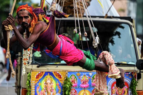 Un hombre con ganchos atravesados en su cuerpo durante el festival hindú Vel en Colombo, Sri Lanka. - Sputnik Mundo