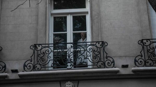 Un vecino de la vicepresidenta argentina, Cristina Fernández, mira por la ventana en el barrio Recoleta, en Buenos Aires - Sputnik Mundo