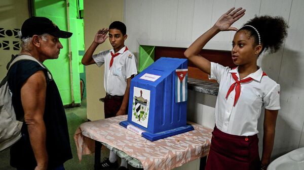 Estudiantes saludan a un ciudadano tras emitir su voto en La Habana - Sputnik Mundo