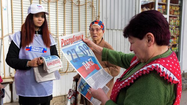 Voluntarias de la comisión regional electoral distribuyen diarios previo al referendo de adhesión a Rusia de la República Popular de Lugansk - Sputnik Mundo