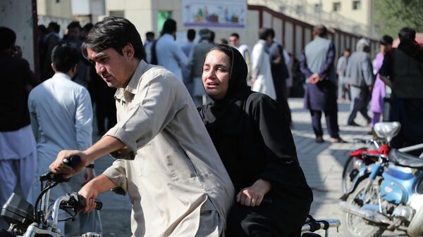 Una mujer llega en moto para buscar a un familiar en un hospital de Kabul tras una explosión en un centro educativo el 30 de septiembre - Sputnik Mundo