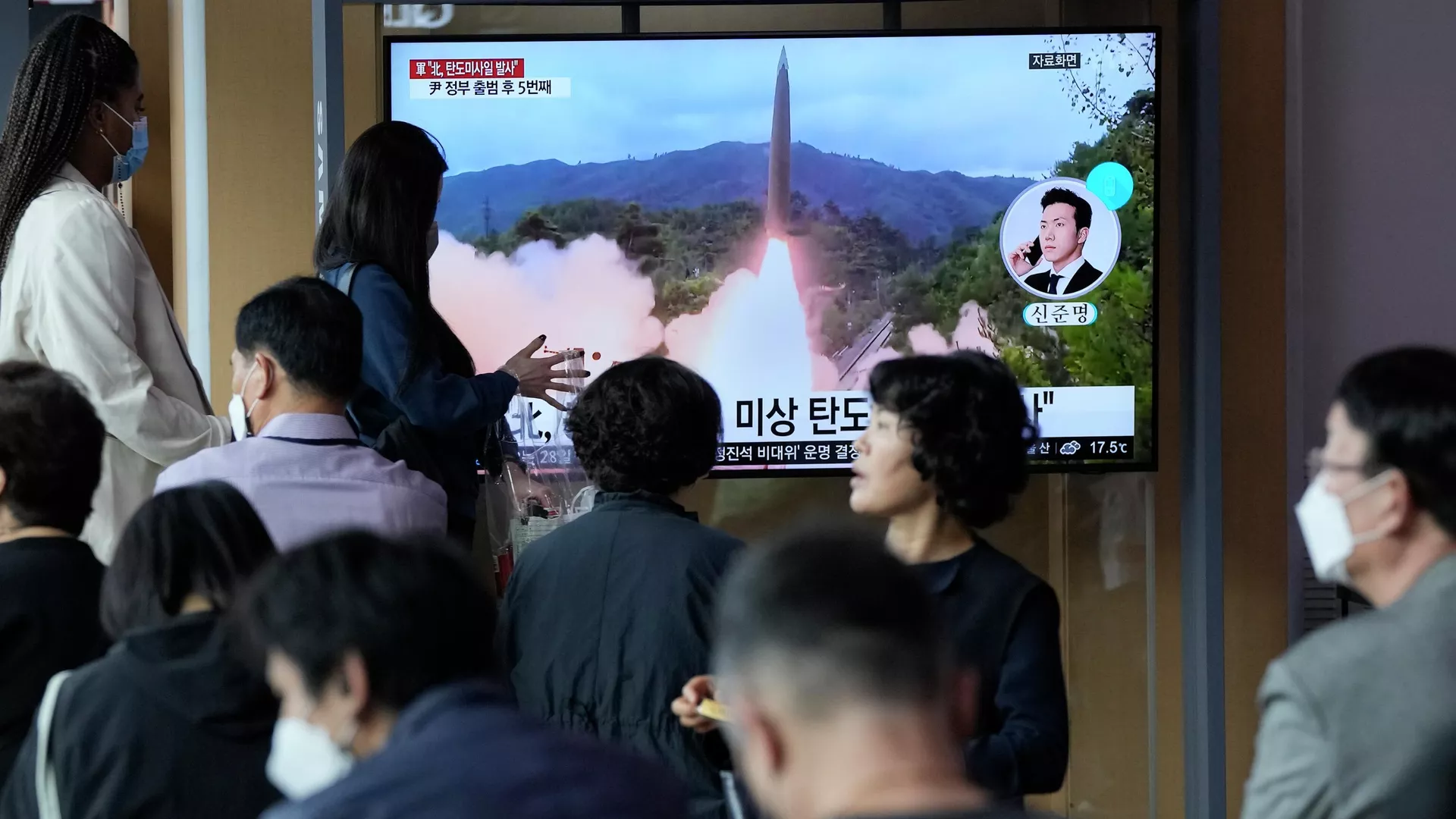 Un grupo de personas observa un programa de noticias que muestra una imagen de archivo del lanzamiento de un misil por parte de Corea del Norte - Sputnik Mundo, 1920, 23.02.2023