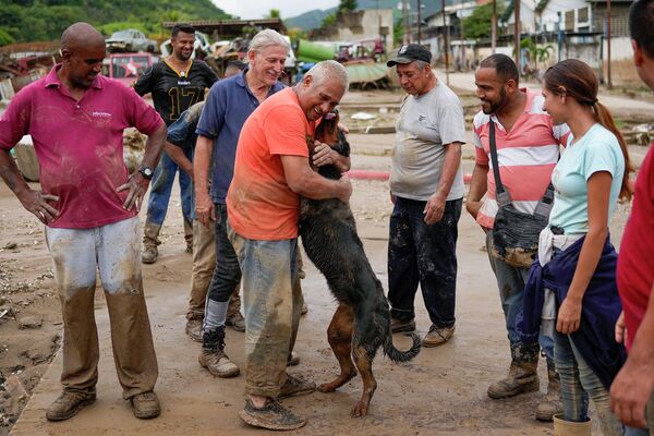 Un residente de Las Tejerías con su perro, rescatado por los vecinos. - Sputnik Mundo