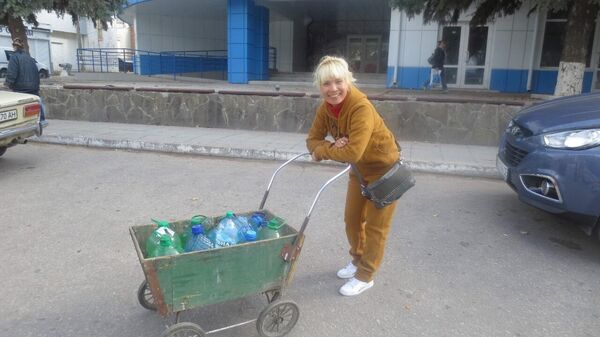 Nguyen Thi Hien transporta agua durante los días en que la ciudad de Lugansk se quedó sin agua y electricidad en 2014 - Sputnik Mundo