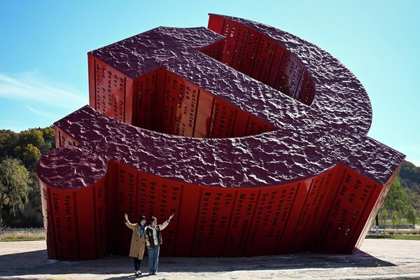 Un grupo de personas se fotografía frente a una escultura de una hoz y un martillo en Yan&#x27;an, provincia noroccidental china de Shaanxi, durante el primer día del XX Congreso del Partido Comunista de China. - Sputnik Mundo