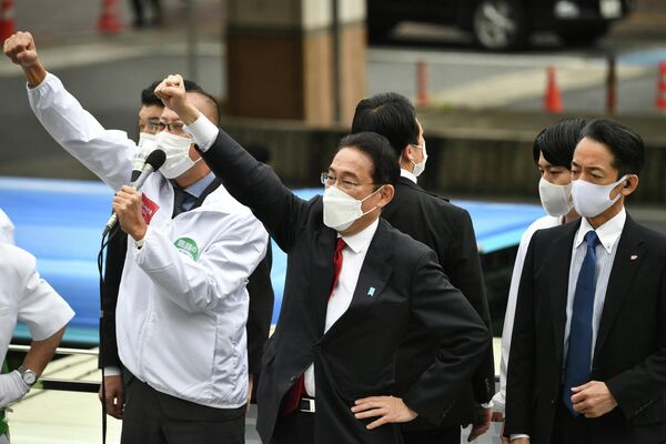 El primer ministro japonés, Fumio Kishida (al centro), durante una campaña de su partido antes de las elecciones en Japón, Tokio. Octubre de 2021. - Sputnik Mundo