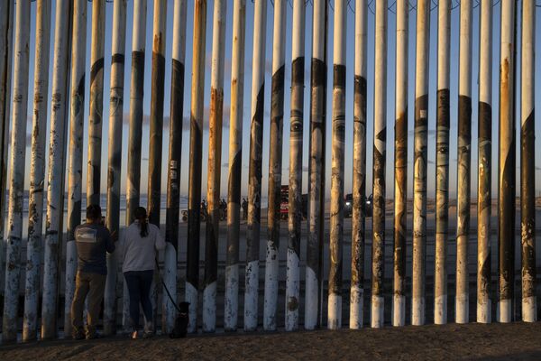 La gente en Playas de Tijuana, México, observa el cadáver de un migrante ilegal que se ahogó mientras intentaba cruzar la frontera con Estados Unidos. - Sputnik Mundo