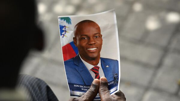 Una persona sostiene una foto del difunto presidente de Haití, Jovenel Moise, durante su ceremonia de conmemoración, 20 de julio de 2021 - Sputnik Mundo