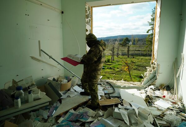 Un soldado de la Milicia Popular de la República Popular de Lugansk en un laboratorio médico destruido en la ciudad de Rubizhne, donde realizaron ensayos de narcóticos analgésicos nasales para los soldados de la OTAN. - Sputnik Mundo