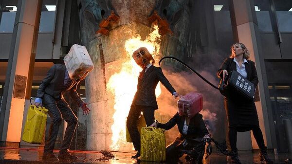 Климатические активисты из группы Ocean Rebellion извергают фальшивую нефть во время демонстрации в Лондоне, Великобритания - Sputnik Mundo