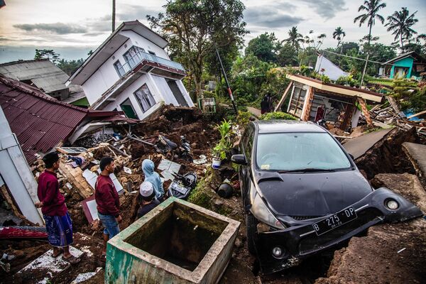 Los habitantes de la ciudad de Cianjur, en la provincia indonesia de Java Occidental, observan las ruinas de su casa tras el devastador terremoto que dejó más de 260 personas muertas. - Sputnik Mundo