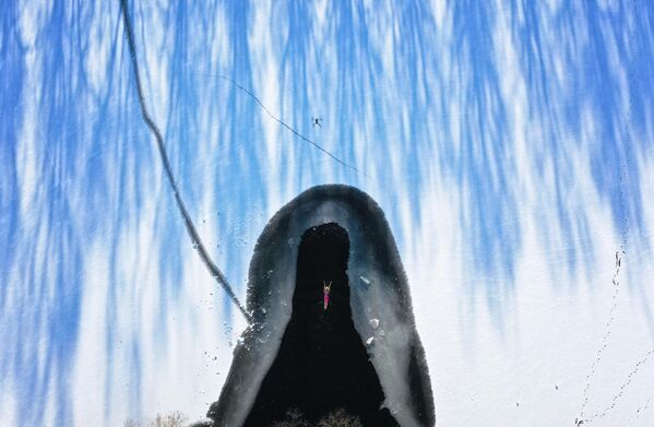 En el norte de China también hay nieve y hielo y las aguas están parcialmente cubiertas de hielo.En la foto: un aficionado a la natación de invierno nada en un lago de la provincia de Liaoning, en el noreste de China. - Sputnik Mundo