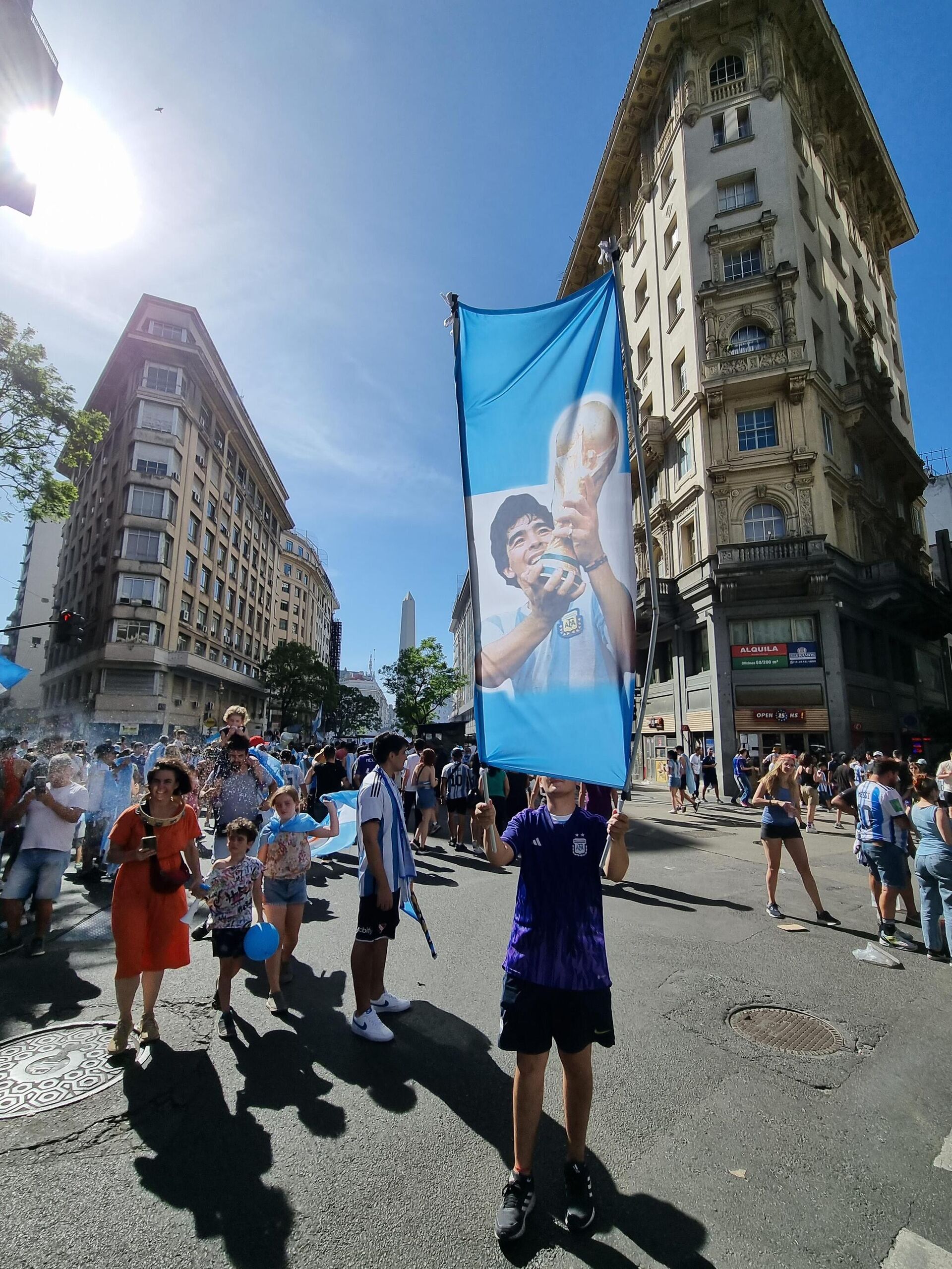 Una persona sostiene una bandera de Diego Armando Maradona durante los festejos de Argentina por su tercera Copa del Mundo - Sputnik Mundo, 1920, 18.12.2022