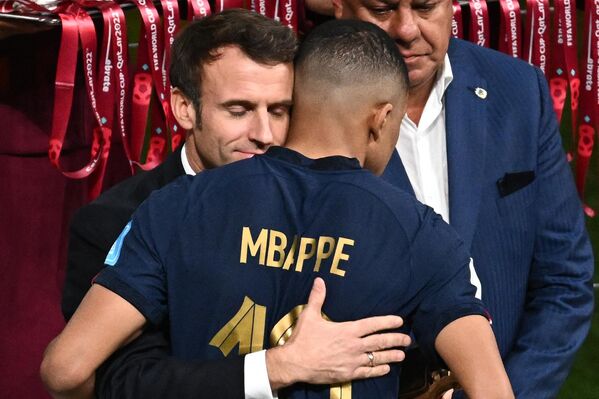 El presidente francés, Emmanuel Macron, abraza al delantero francés Kylian Mbappé para animarle tras perder el Mundial de Catar 2022. - Sputnik Mundo