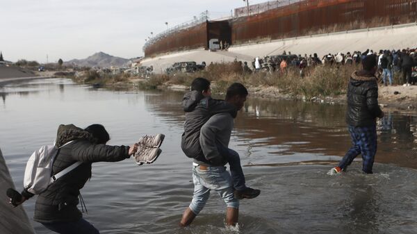 Мигранты пересекают Рио-Гранде в направлении американо-мексиканской границы в Сьюдад-Хуаресе, Мексика - Sputnik Mundo