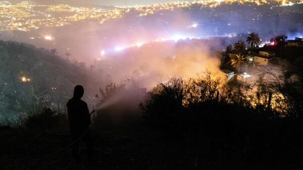 Un hombre observa desde una colina los incendios que afectan al menos a 200 viviendas en la ciudad de Viña del Mar, Chile, el 23 de diciembre de 2022.  - Sputnik Mundo